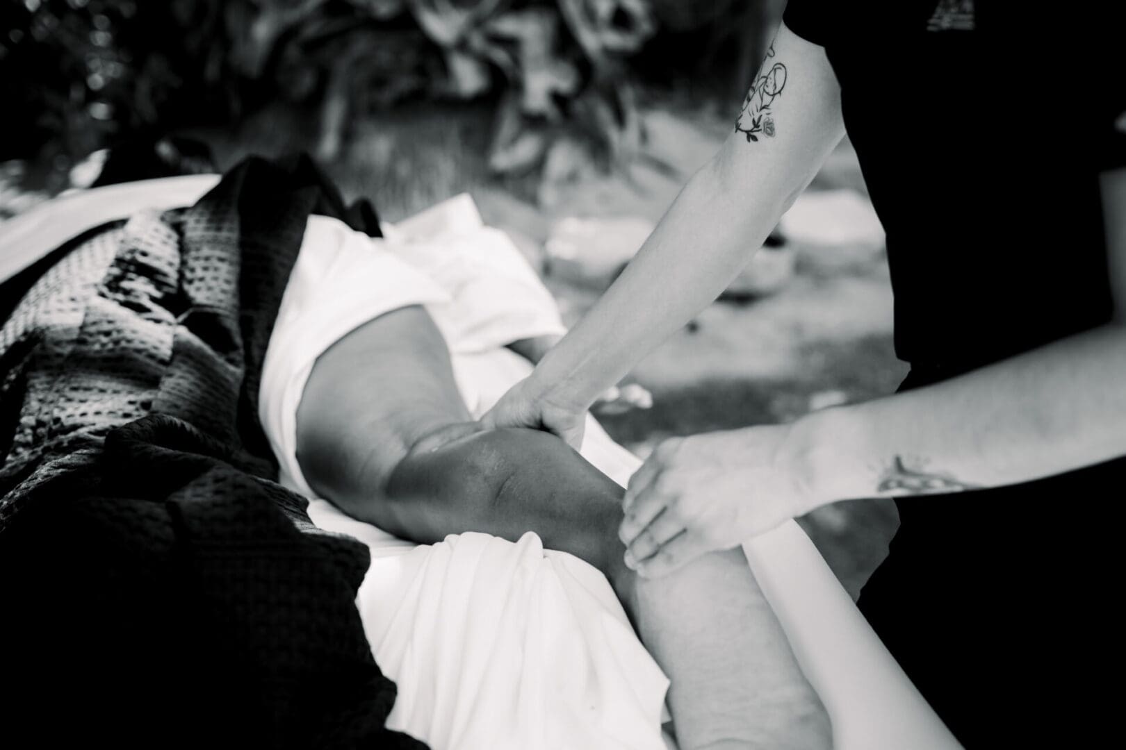 Hands tightly gripping someone's arm in a black-and-white photo.